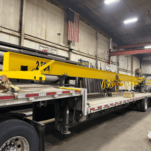CraneWerks yellow 2 ton top running single girder overhead bridge crane loaded up on a bi-level trailer bed for delivery in Morristown, IN